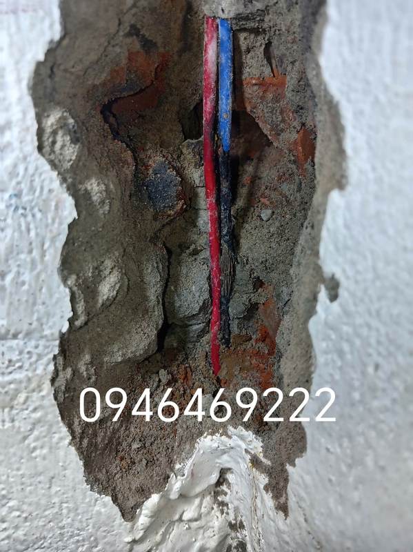 Cận cảnh dây đỏ và dây xanh có vùng cháy xém trong hốc tường