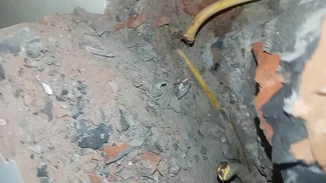 Dây điện màu vàng nằm sâu trong hốc tường sau lớp trát tại Hai Bà Trưng