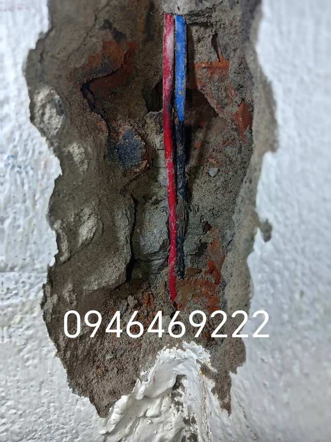 Hốc tường được mở để quan sát dây điện đỏ xanh và vùng hư hỏng