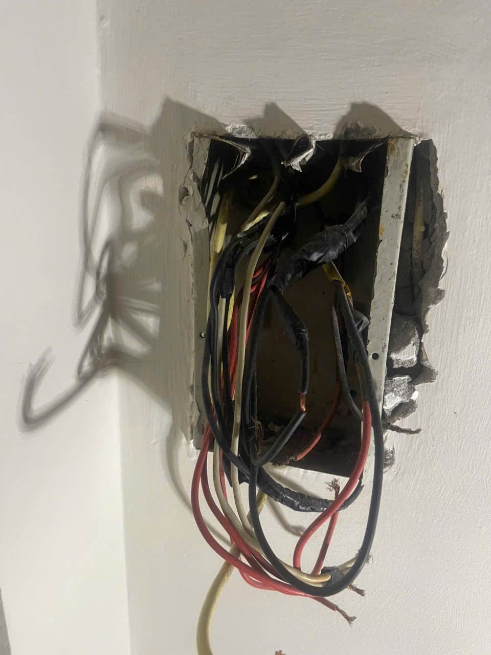 Hộp dây điện âm tường được mở để kiểm tra các đầu nối