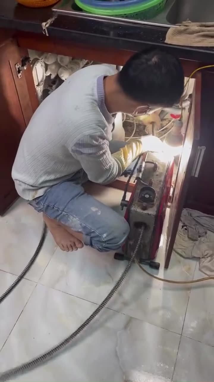 Thợ kiểm tra ống thoát nước dưới chậu rửa bằng camera
